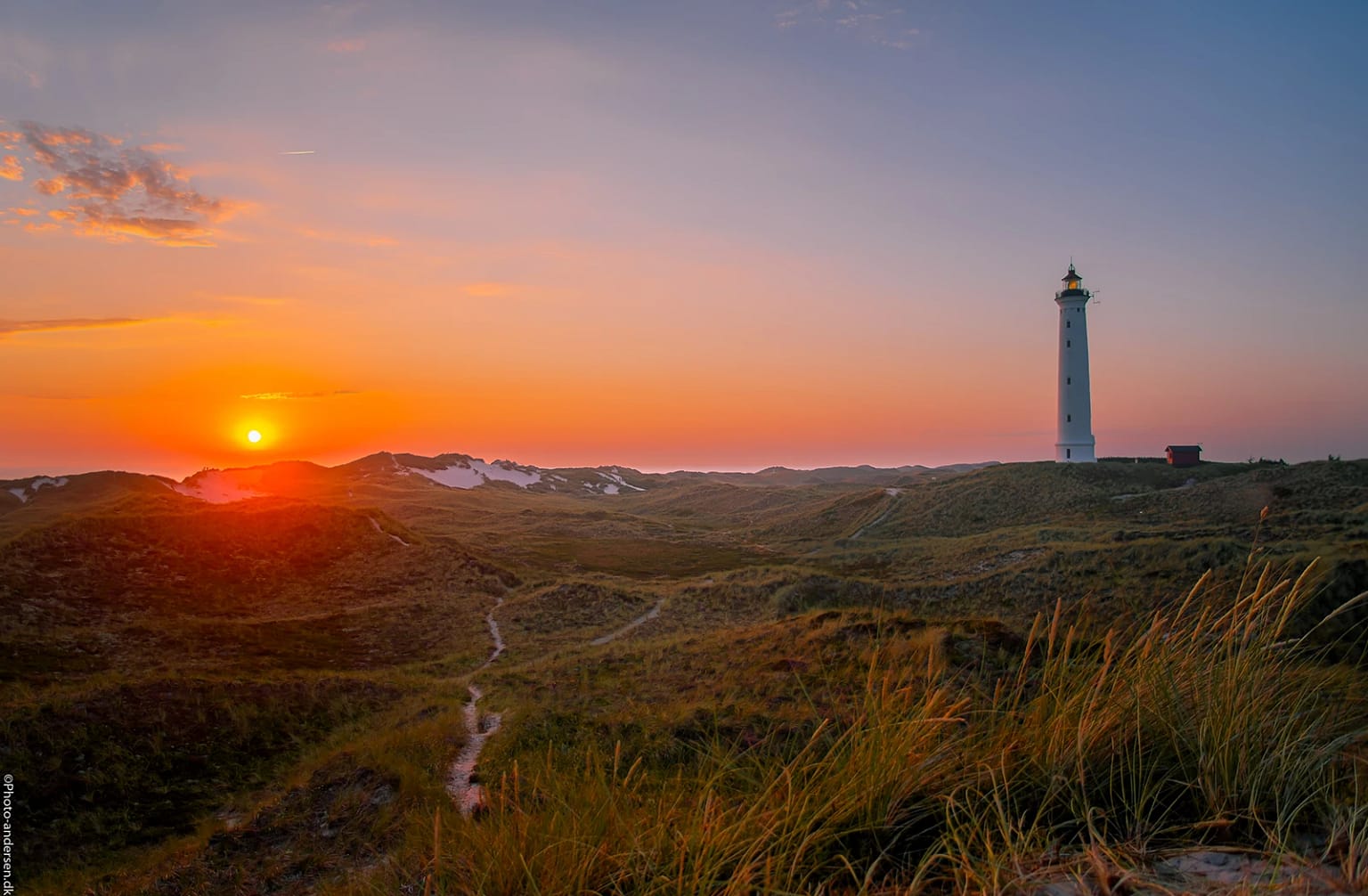 I solnedgangen ved Nørrelyngvild Fyr, Hvide Sande, Danmark kan du forvente en smuk og stemningsfuld oplevelse. Når solen nærmer sig horisonten, vil himlen blive fyldt med varme farver som orange, gyldne nuancer.