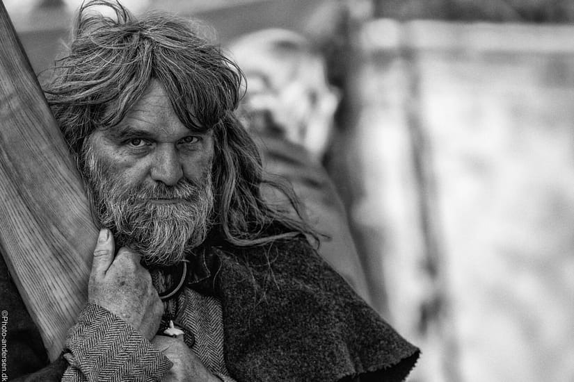 Sort hvid fotografering af en viking fra Ribe Vikinge center, hvor han stod under teltet og solen lyste gennem teltet